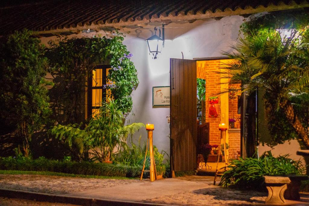 una casa con una puerta iluminada por la noche en Hotel Las Marias, en Antigua Guatemala