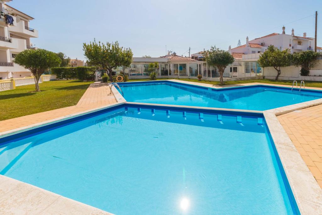 a large blue swimming pool in front of a building at Sunny Home Oura By ALzira in Albufeira