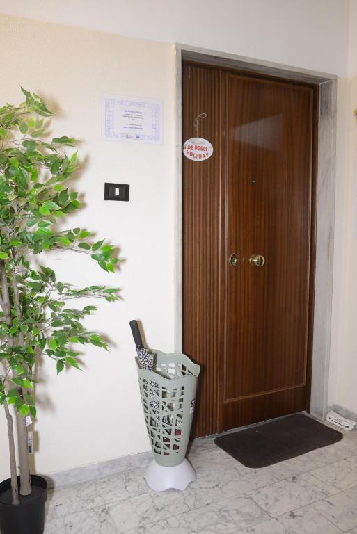 un corridoio con una porta in legno e una pianta di De Rossi Holiday a Bari