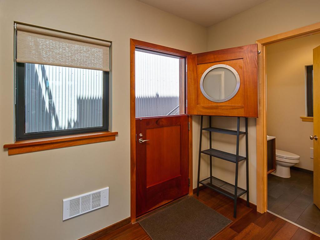 a bathroom with a toilet and a wooden door at Island Inn at 123 West in Friday Harbor