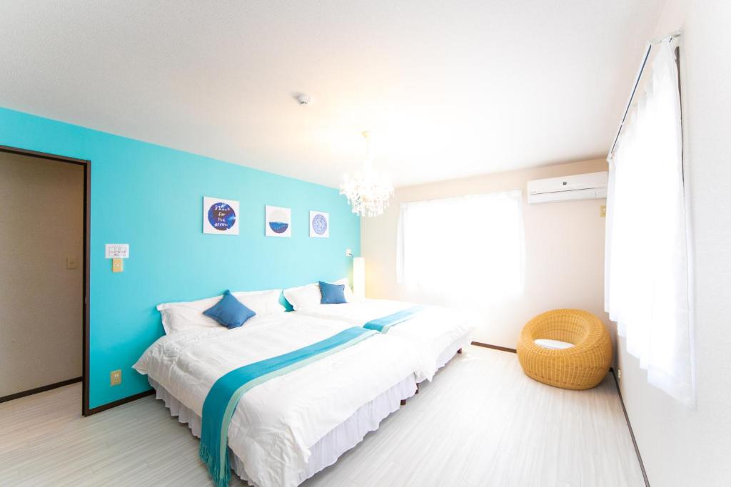 sypialnia z dużym łóżkiem z niebieską ścianą w obiekcie Awaji Seaside Resort in Ikuha w mieście Ikuha