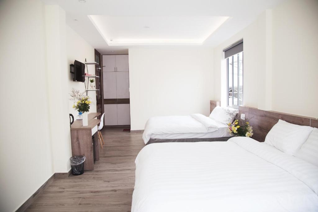 um quarto de hotel com duas camas e uma janela em Pontus Hotel em Da Lat