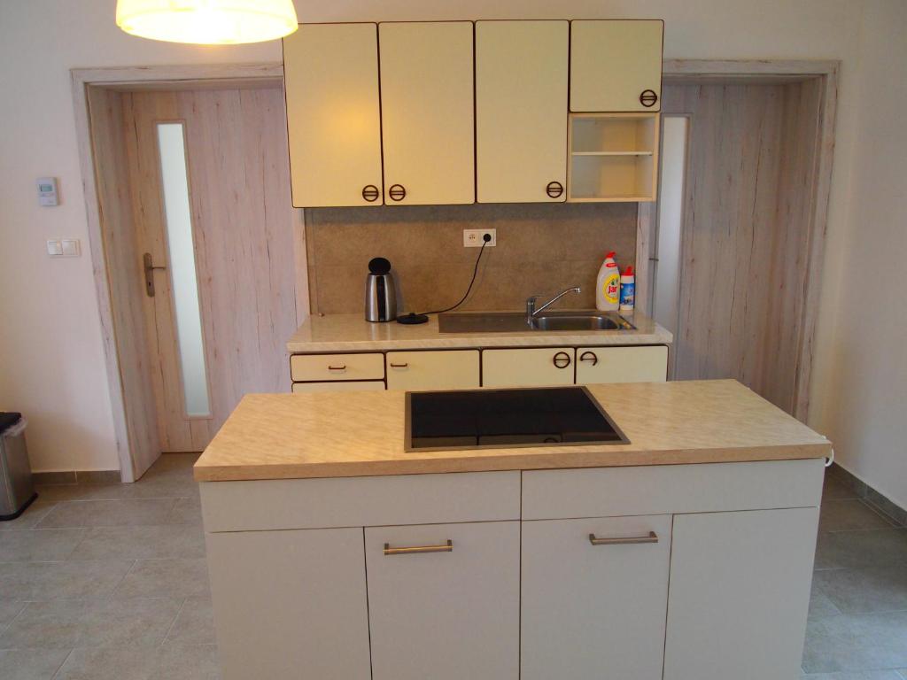 a kitchen with white cabinets and a sink at Apartmán GUTINO in Česká Třebová