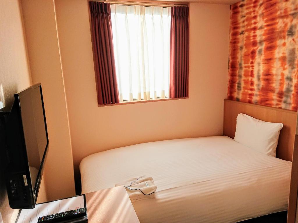 Postel nebo postele na pokoji v ubytování SAKURA SKY HOTEL KASHIWA(桜スカイホテル柏)