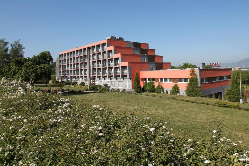 a building with a grassy field in front of a building at Hotel Panorama in Teplice