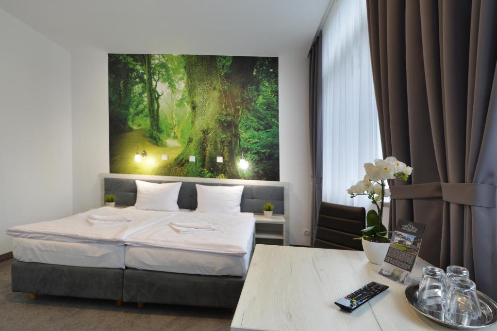1 dormitorio con 1 cama y una gran pintura en la pared en Hotel Roztocze, en Zwierzyniec