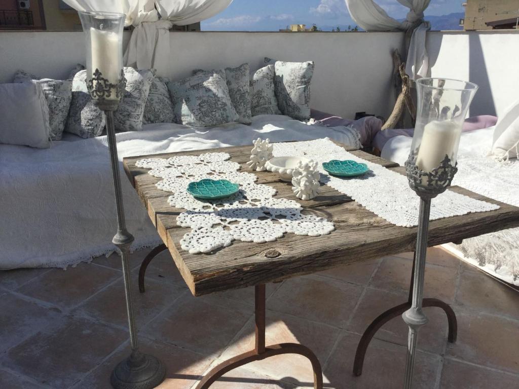 einen Tisch mit zwei Kerzen auf dem Bett in der Unterkunft Il Giardino d'Ulisse in Reggio di Calabria