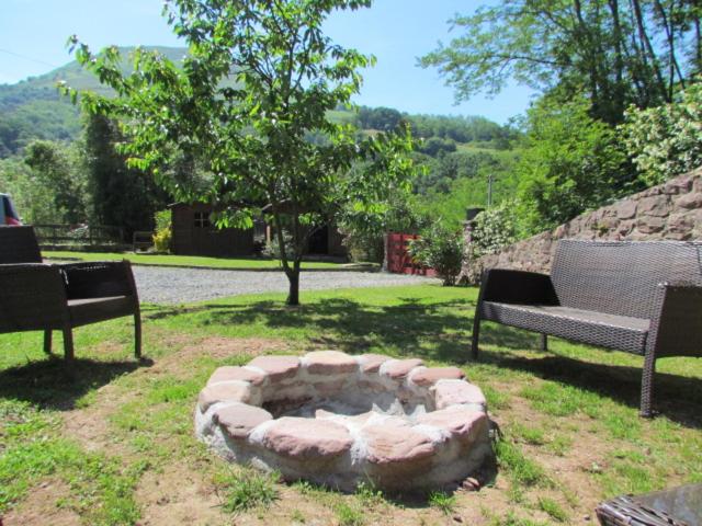a fire pit in a yard with two benches at GITE IBARLA BORDA in Bidarray
