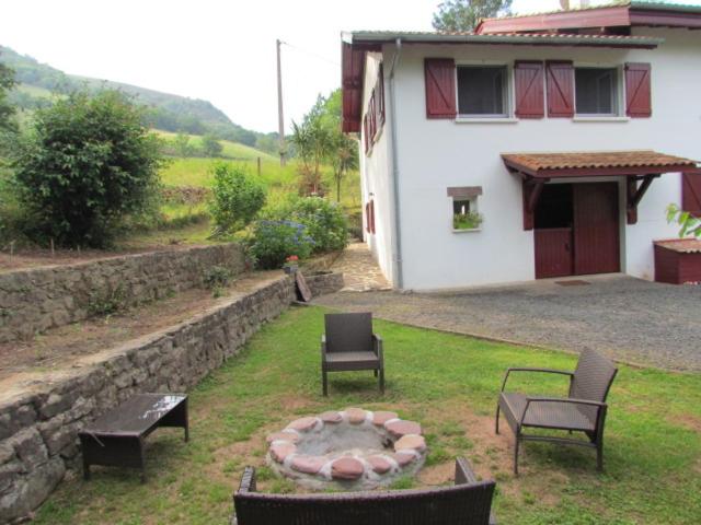 a yard with chairs and a fire pit in front of a house at GITE IBARLA BORDA in Bidarray