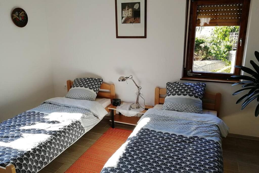 two beds sitting in a room with a window at ZRM center in Idrija