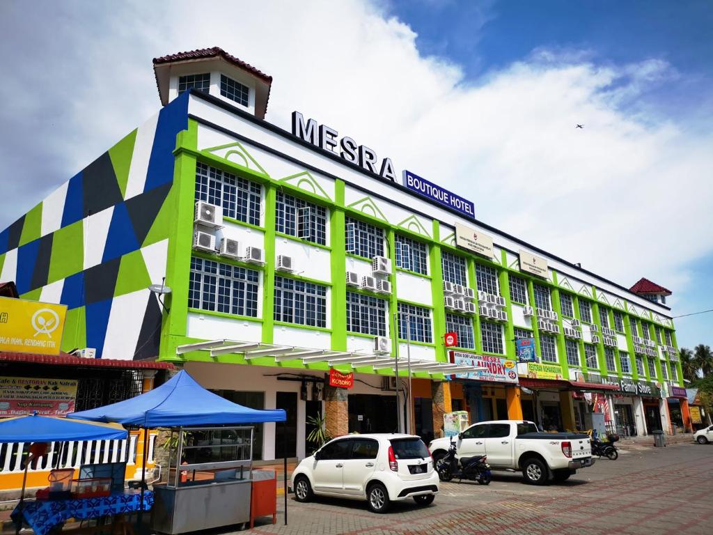 un gran edificio con coches estacionados frente a él en Mesra Boutique Hotel, en Port Dickson