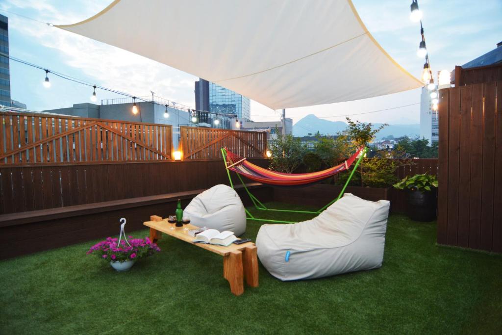 a patio with two chairs and a hammock on a balcony at Insadong Hostel in Seoul