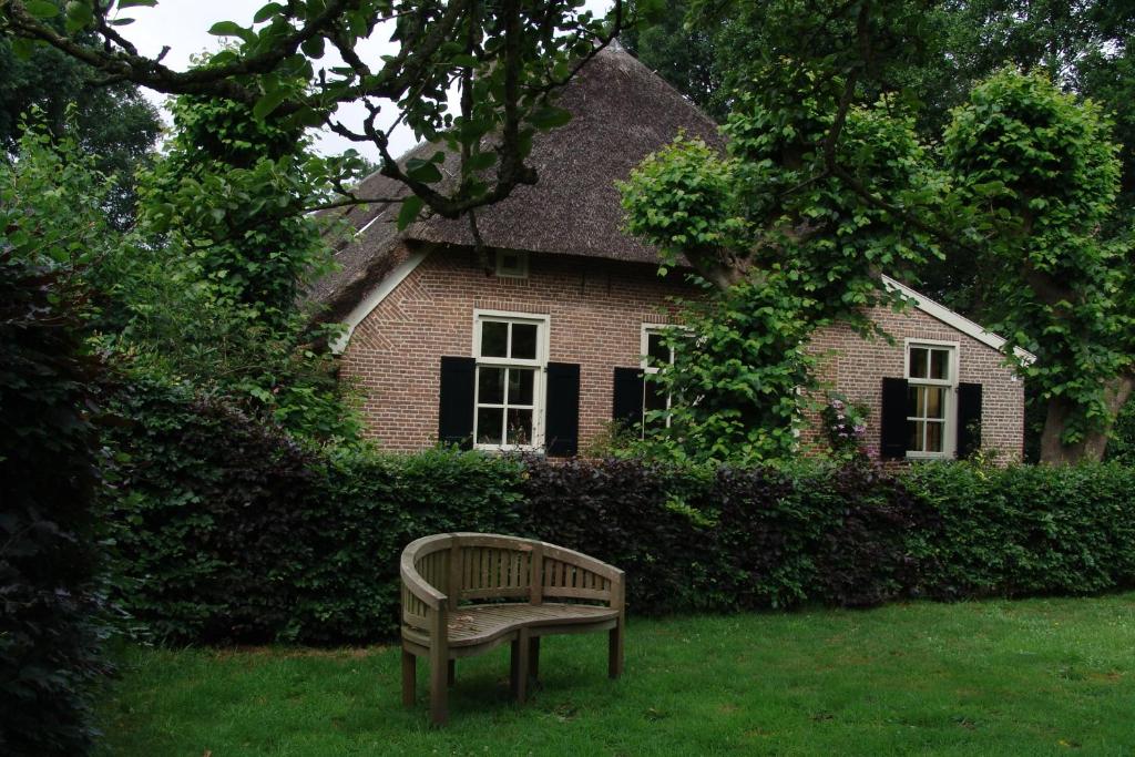 RuinenにあるHoeve Den Anholtの家の前の芝生に腰掛けたベンチ