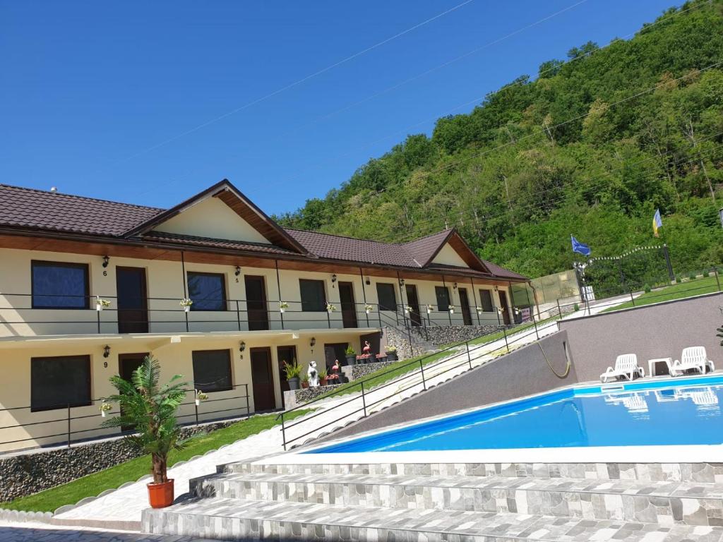 a resort with a swimming pool in front of a mountain at Vila Donau in Dubova