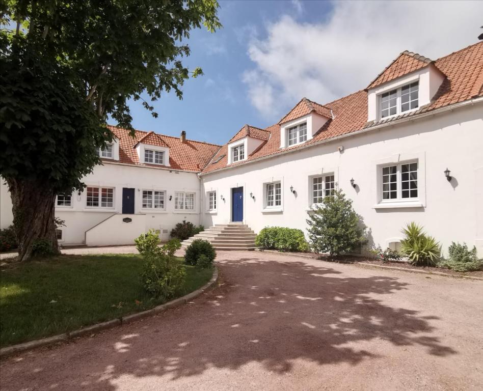 a large white house with a driveway at Gîte les Hortensias in Marquise