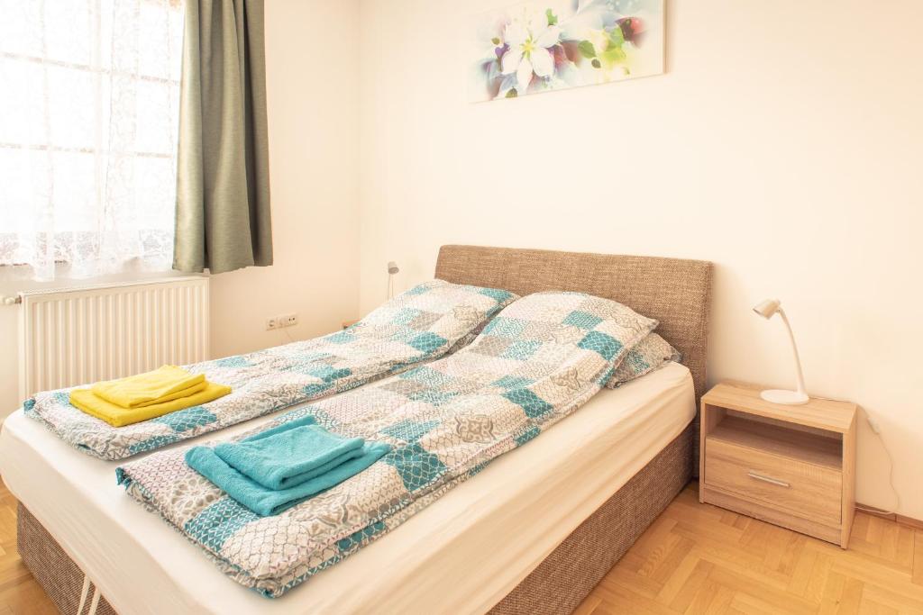 Una cama con edredón en un dormitorio en Modor Apartman, en Alsópáhok