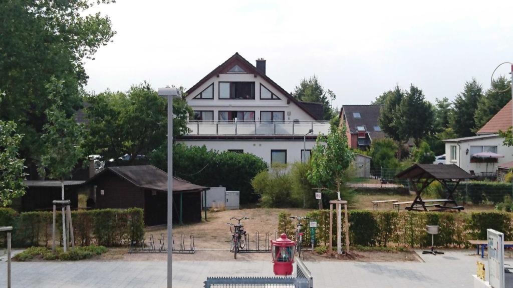 a white house with a red fire hydrant in front of it at Haus Warnowblick Objekt 36737 in Rostock