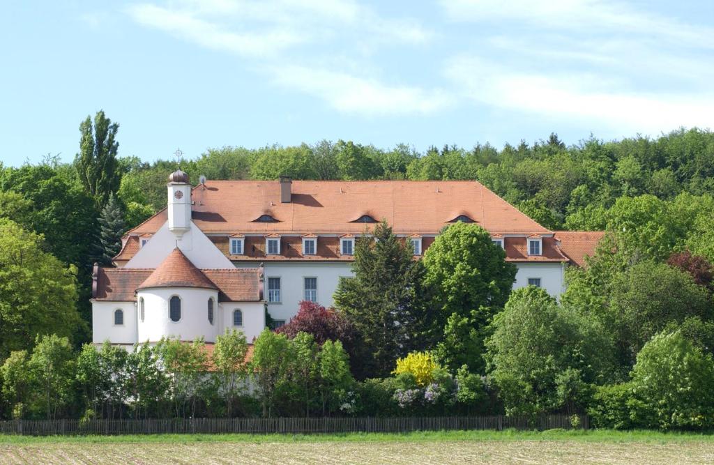 een groot wit huis met een rood dak bij Tagungshaus Reimlingen in Reimlingen