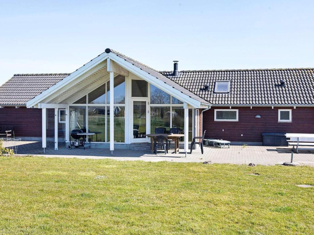 una casa con una gran extensión de cristal a un patio en Four-Bedroom Holiday home in Idestrup 3 en Bøtø By