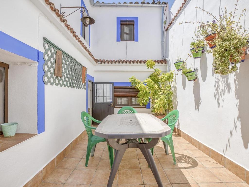patio ze stołem i krzesłami przed domem w obiekcie Villa in Carcabuey near Sierras Subbeticas Park w mieście Carcabuey