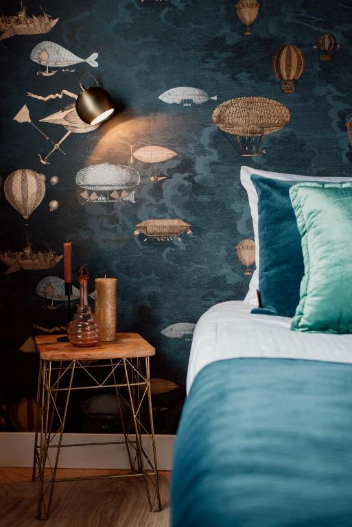 een slaapkamer met een bed en een muur versierd met planeten bij Hotel Steeds aan Zee in Katwijk