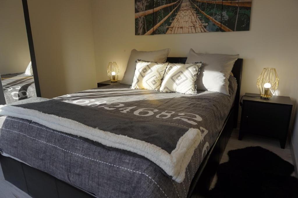 una camera da letto con un letto grande con due lampade di Maison de standing avec jardin à 200m de la plage a Berck-sur-Mer