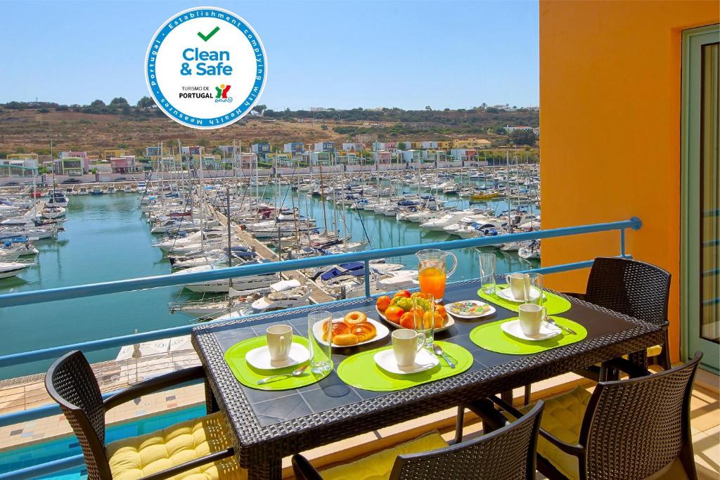 - une table avec de la nourriture sur un balcon avec un port de plaisance dans l'établissement Marina Sand Residence, à Albufeira
