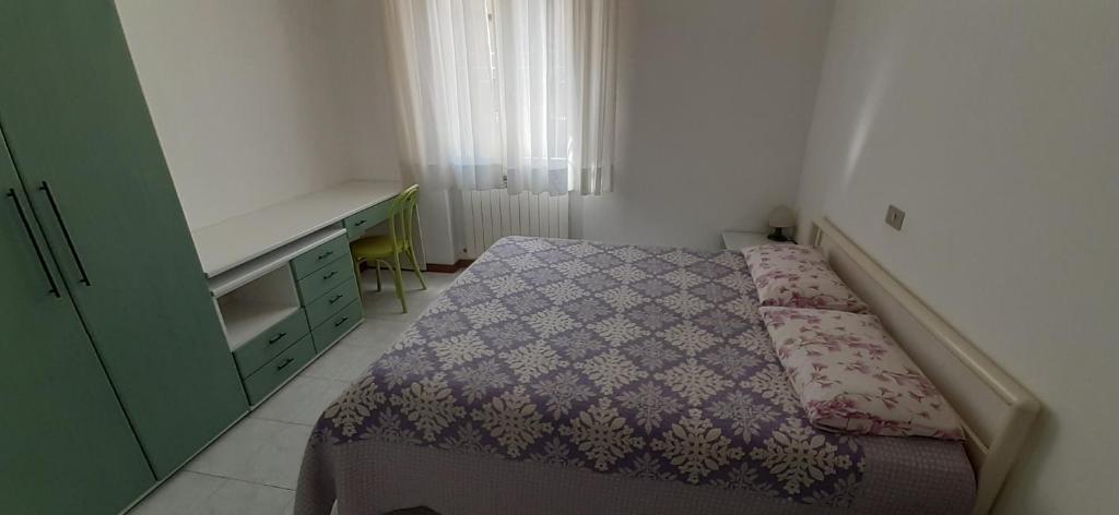 a small bedroom with a bed and a desk at Appartamento Raffaello in Cattolica