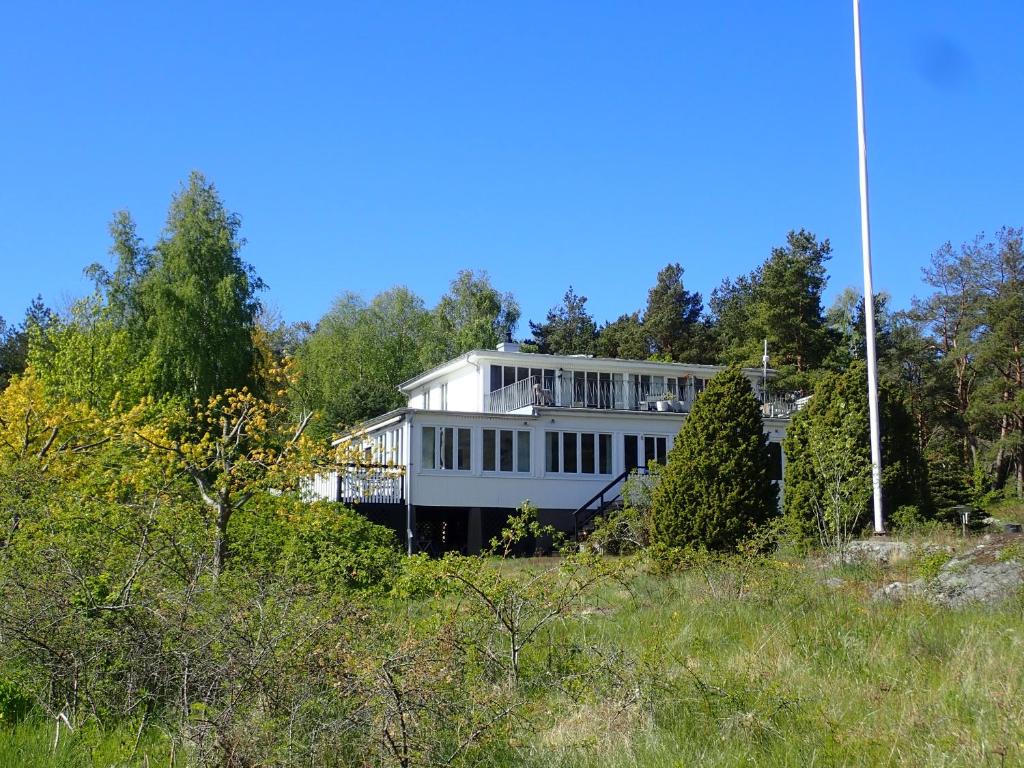 duży biały dom siedzący na szczycie wzgórza w obiekcie Kilesandsgården w mieście Sydkoster