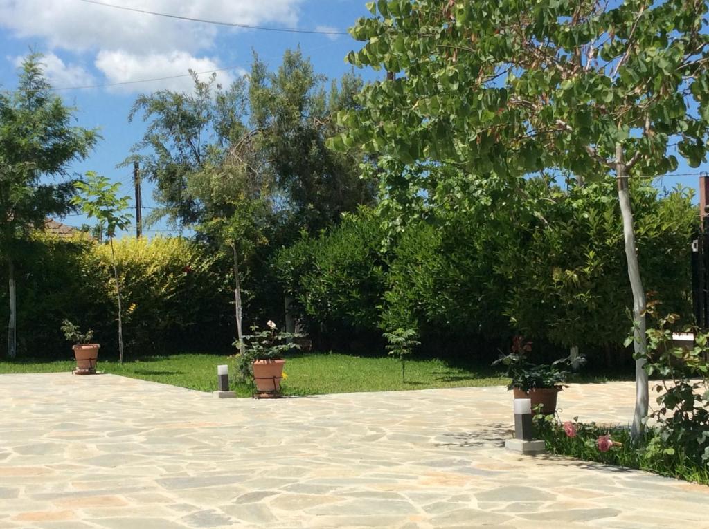 un patio con macetas en un jardín en Kardiakafti Village en Gastoúni