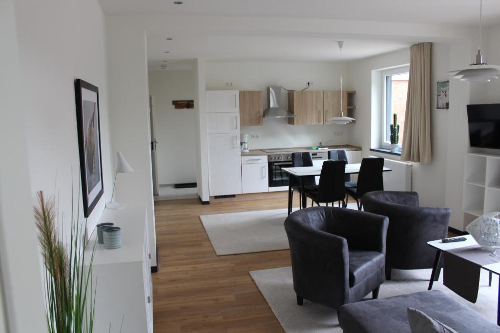 a living room and kitchen with a table and chairs at Dünenhaus Wohnung 10 in Travemünde