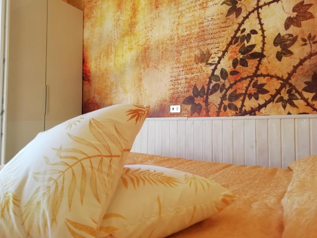 łóżko z poduszką i obrazem na ścianie w obiekcie Hotel Eva La Romantica w mieście Moneglia
