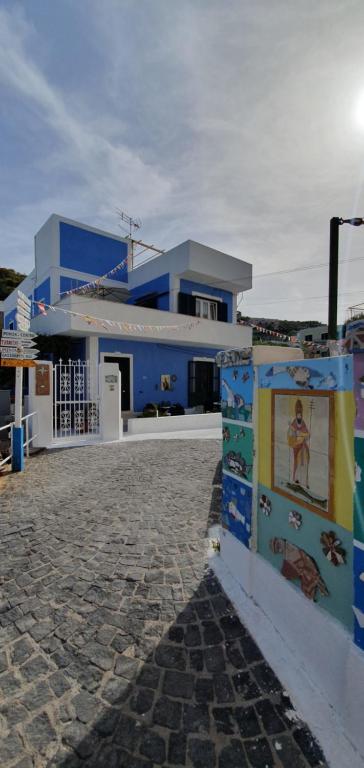um edifício azul com uma entrada de pedra em frente em Rosa Dei Venti Ponza em Ponza