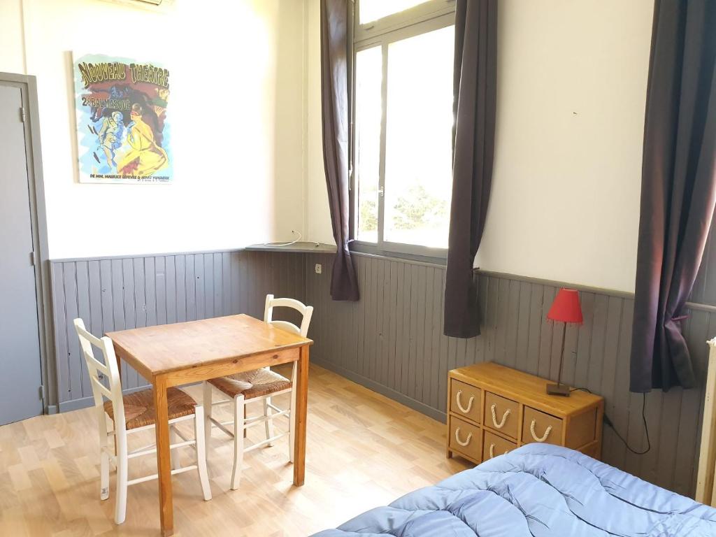 sypialnia ze stołem, stołem i łóżkiem w obiekcie Camping des 2 Rives- Chambres w mieście Étang-sur-Arroux