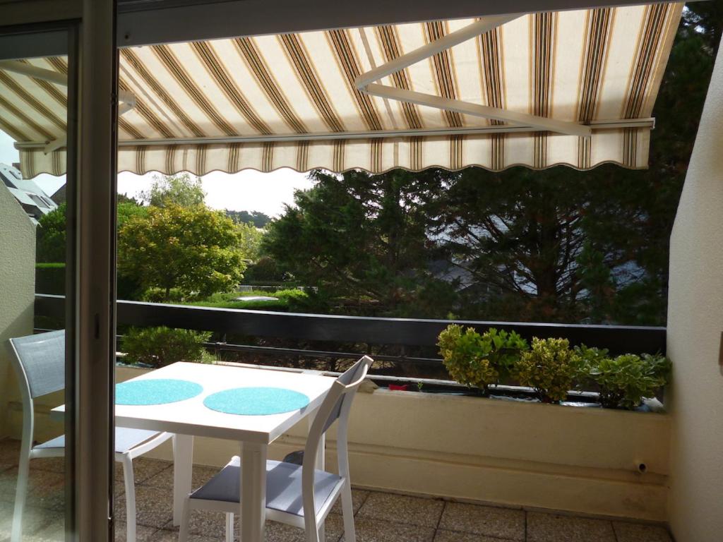 a patio with a table and chairs on a balcony at Studio LUMINEUX avec belle TERRASSE sur ESPACES VERTS, 100m PLAGE in Carnac-Plage