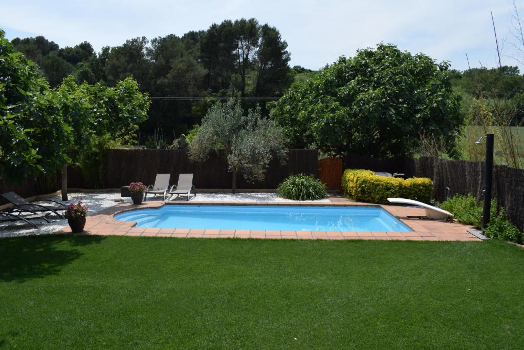 una piscina in un cortile con prato di Casa Particular a Banyoles