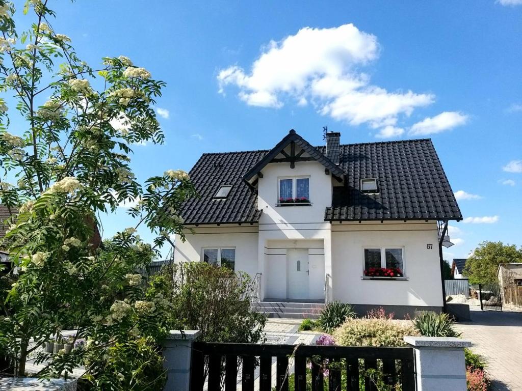 Biały dom z czarnym dachem w obiekcie E&S_ Apartament w mieście Milicz