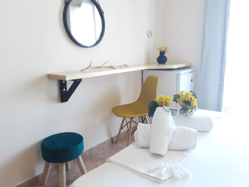a room with a table and chairs and a mirror at Poseidon Rooms in Kala Nera