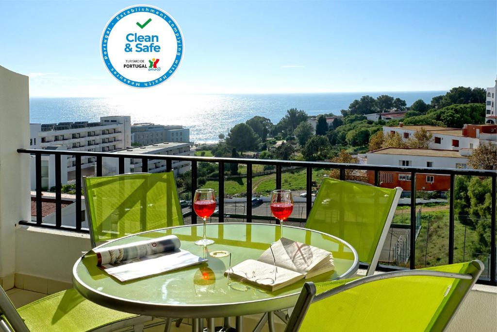 balcón con mesa y 2 copas de vino en Apartamentos do Atlantico, en Albufeira