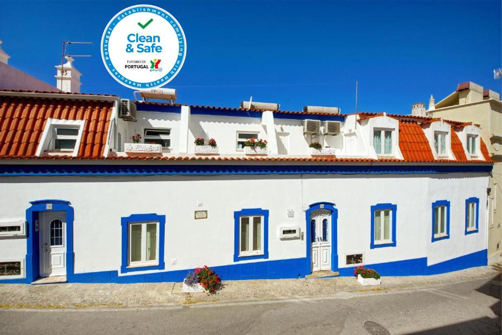 un bâtiment blanc et bleu avec un panneau indiquant propreté et sécurité dans l'établissement Apartamentos Tucha, à Albufeira