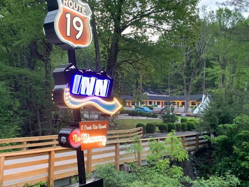 a sign for a motel with various neon signs at Route 19 Inn in Maggie Valley