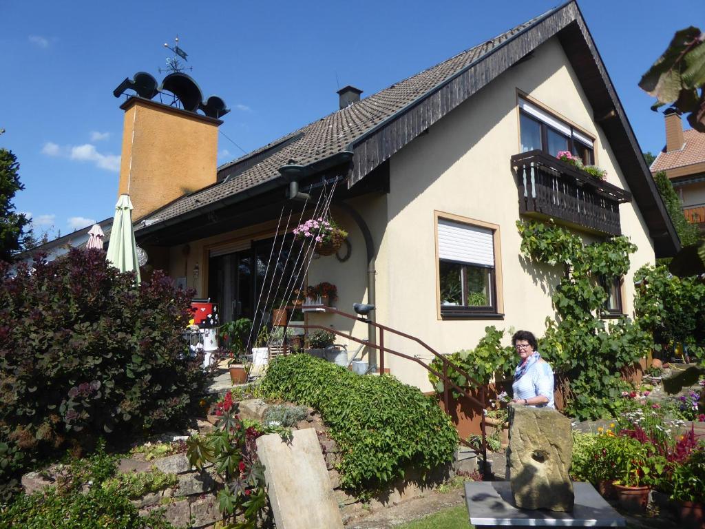 a woman sitting in front of a house at Haus Sonneneck in Bad Bocklet