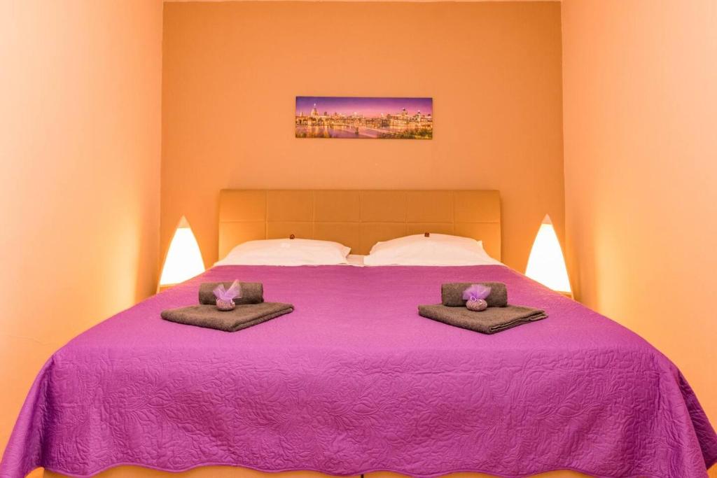 a bedroom with a purple bed with two pillows on it at Apartman Sanja in Pula