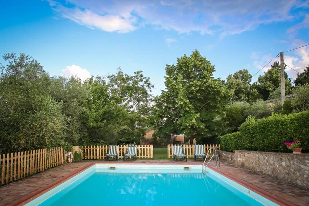 ein Pool in einem Garten mit einem Zaun in der Unterkunft Villa Capannina in Vico dʼArbia