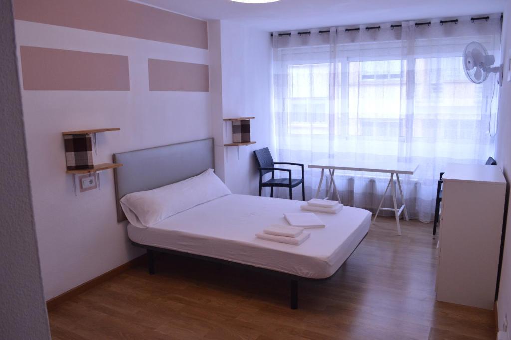 Habitación pequeña con cama y mesa en ArArAt Hostel, en Santiago de Compostela