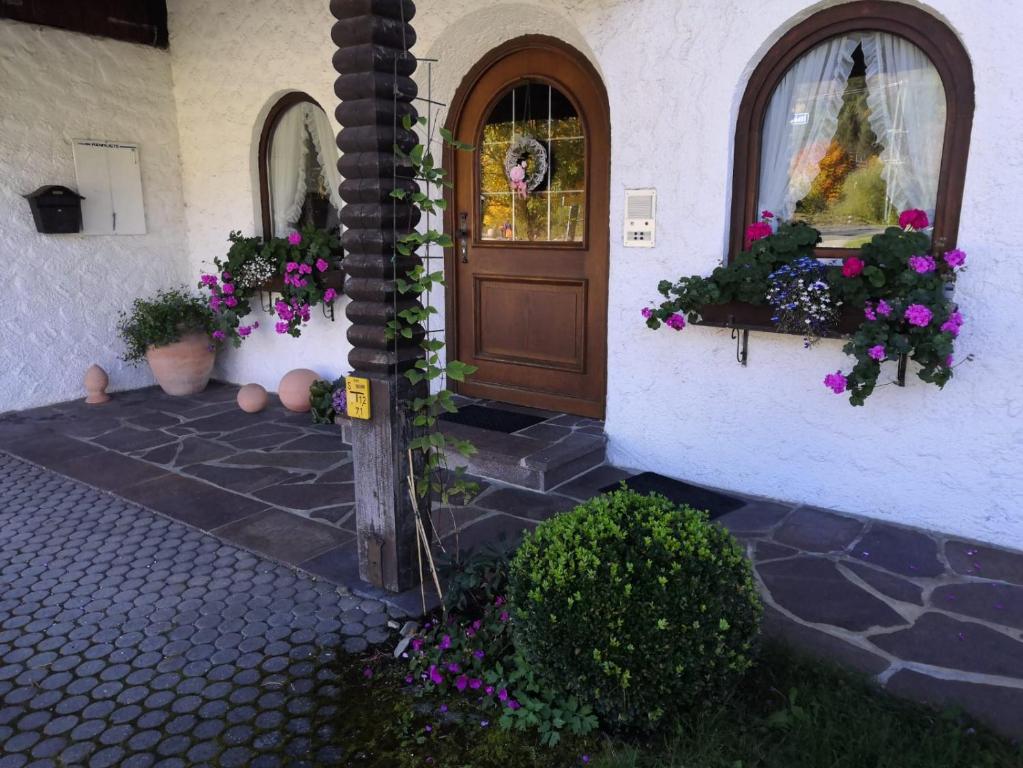 eine Haustür eines Hauses mit Blumen und Pflanzen in der Unterkunft Gästehaus Kayetan in Klais