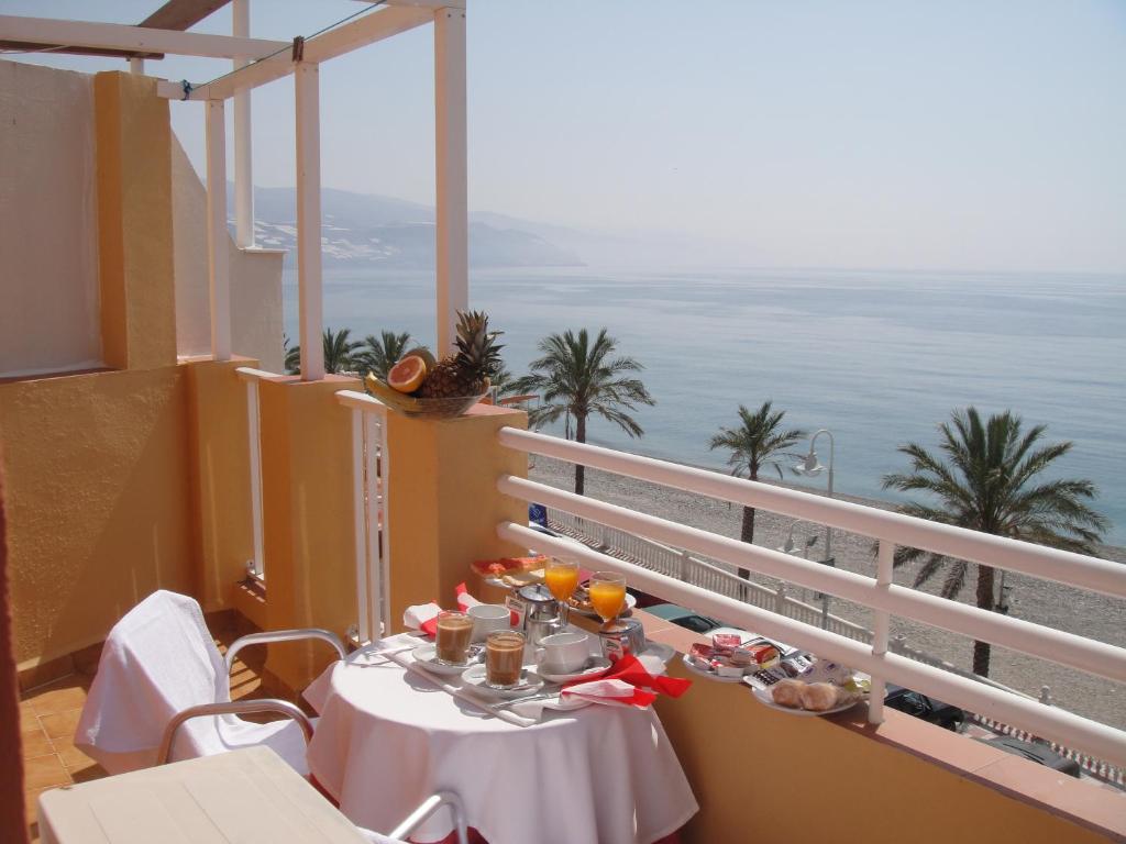 una mesa en un balcón con vistas al océano en HOSTAL COSTA SOL, en Castell de Ferro