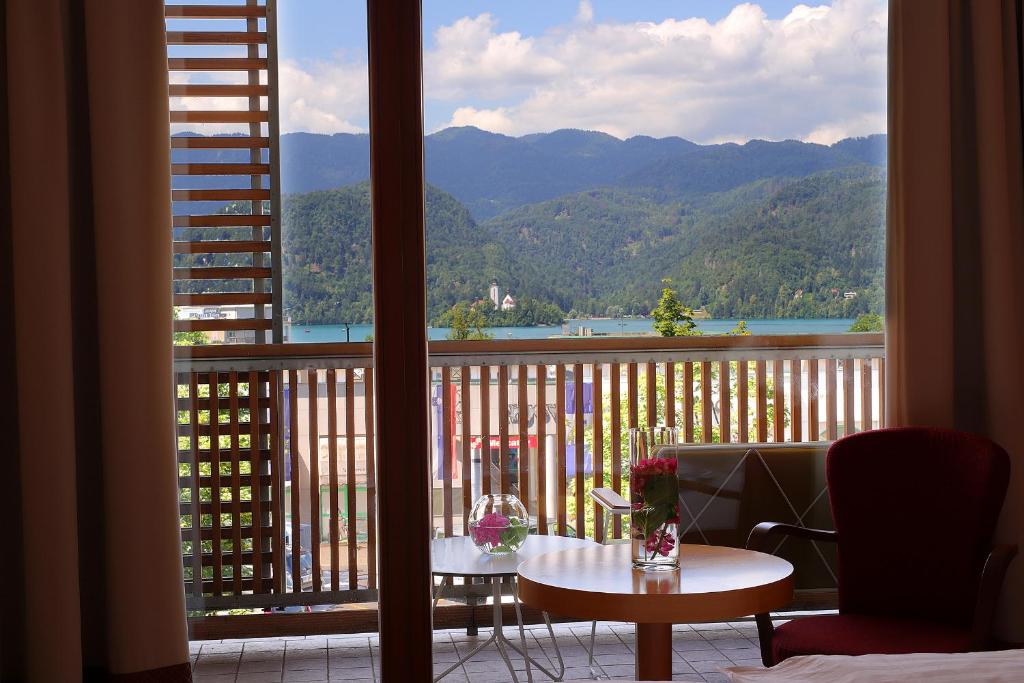 balcón con mesa y vistas a la montaña en Hotel Lovec, en Bled