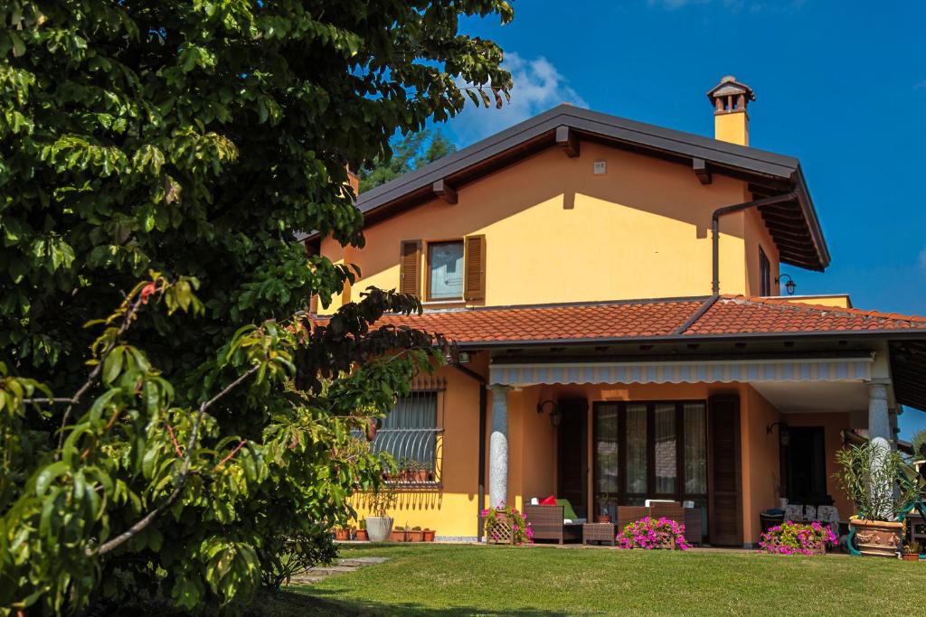 una gran casa amarilla con techo en Alla Camelia B&B, en Brunello