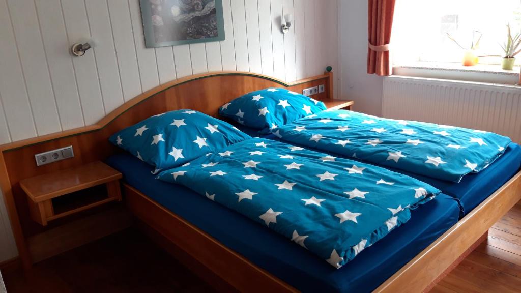 a bed with blue sheets with stars on it at Gasthaus Zehrermühle in Schönberg